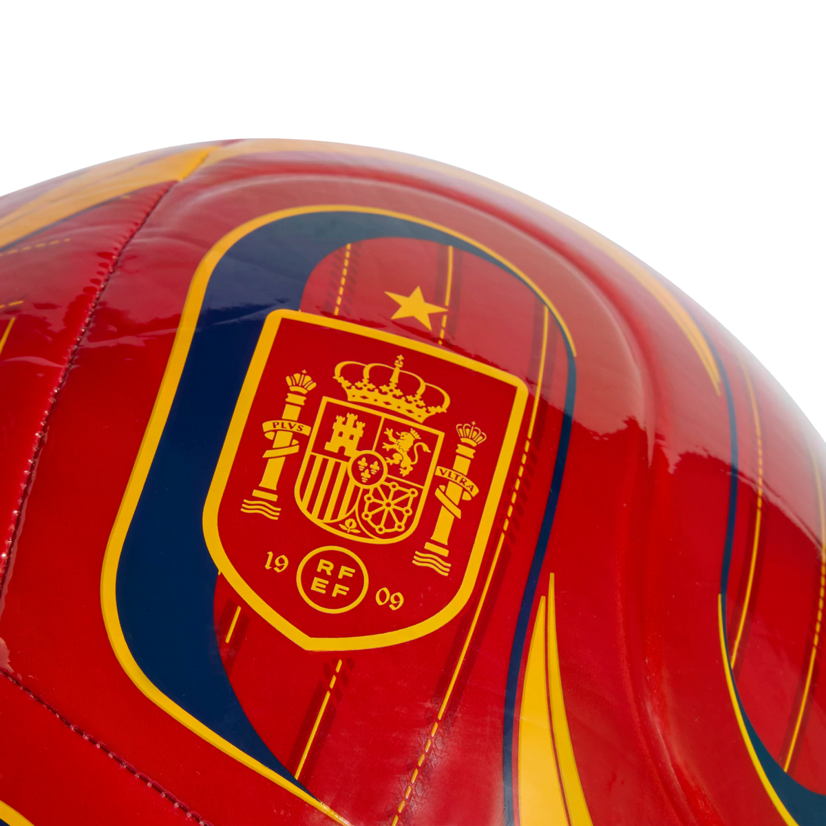 Close-up of a glossy red soccer ball featuring the Royal Spanish Football Federation crest in yellow and red, with a single gold star above it.