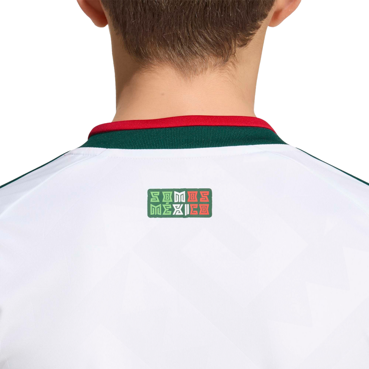 Back view of a white sports jersey with a green and red collar. A small logo below the collar reads "SOMOS MÉXICO" in stylized lettering with the colors of the Mexican flag.