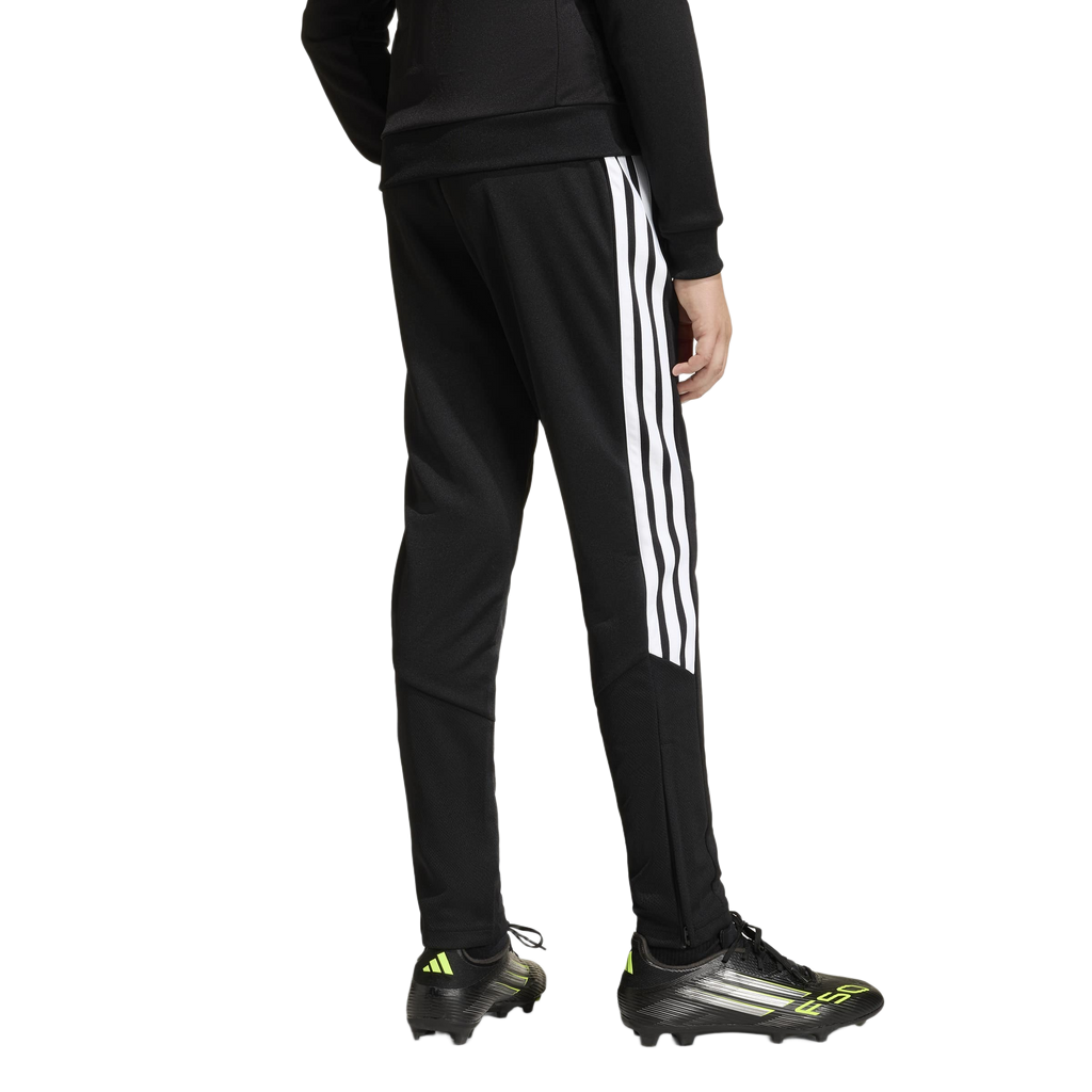 Rear view of a person in black Adidas track pants with white stripes and black F50 soccer cleats with neon accents on a white background.