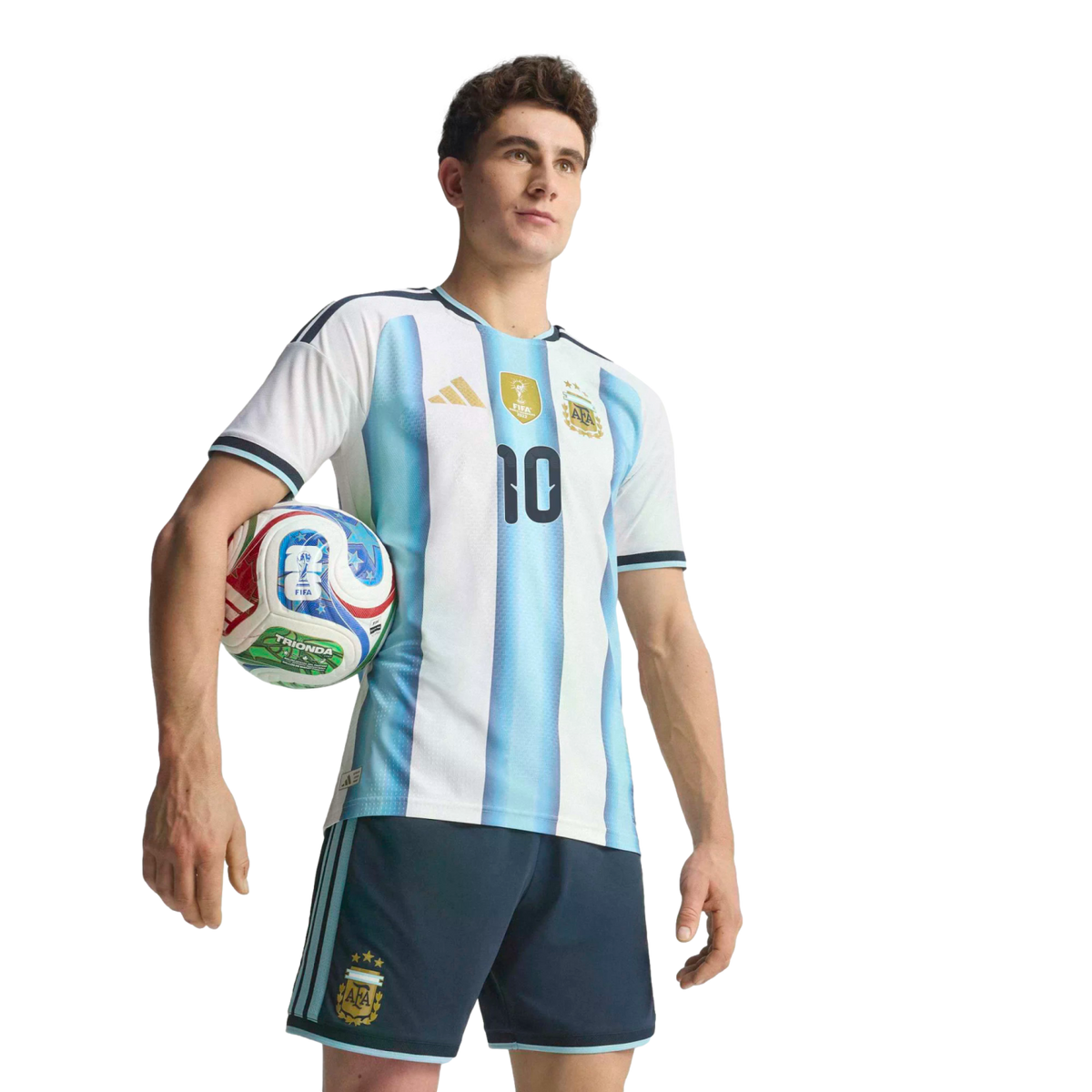 Man in a blue and white striped Argentina soccer jersey with number 10, holding a football under his arm against a black background.