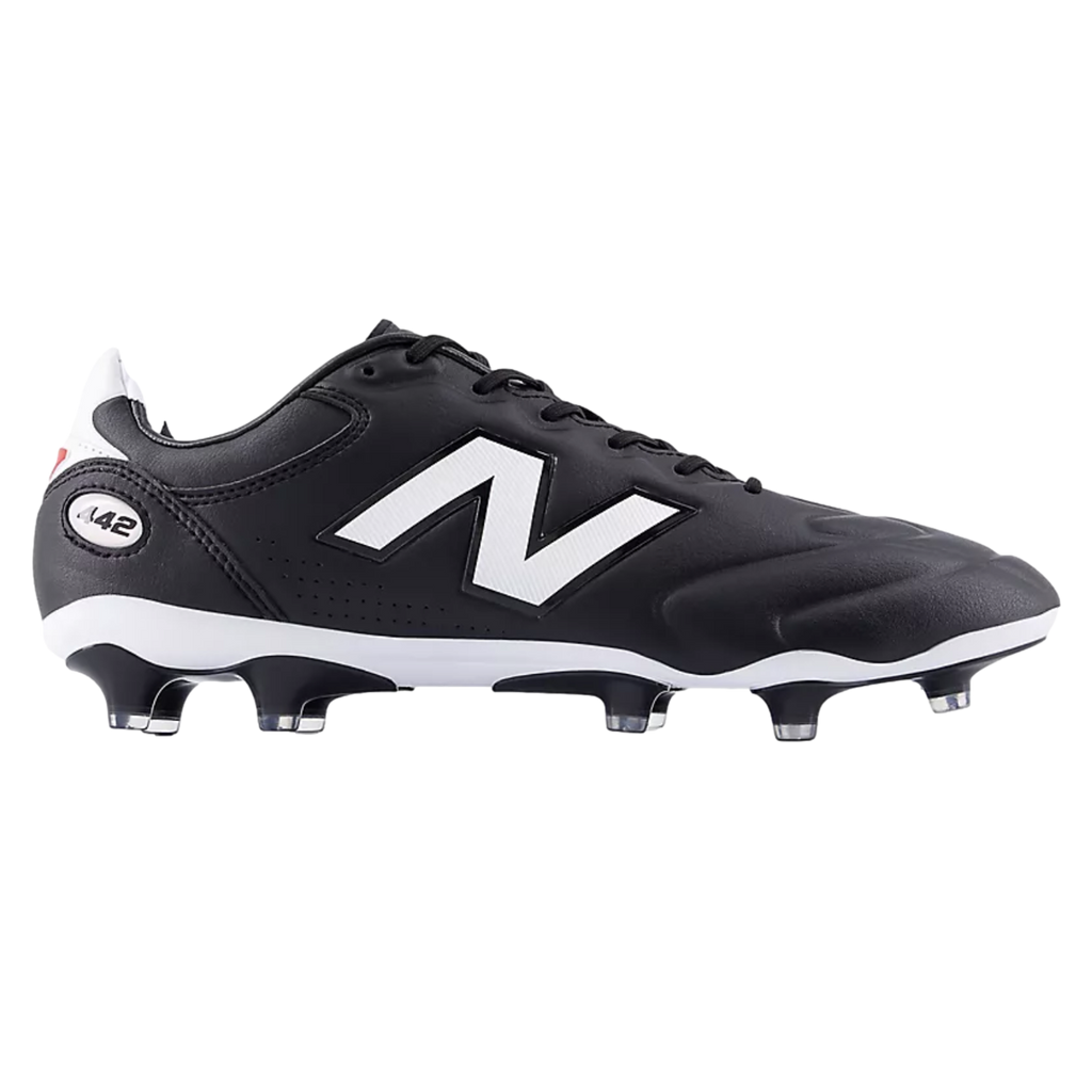 A side view of a black New Balance 442 soccer boot featuring a large white logo, a white midsole, and black studs with clear tips against a solid black background.