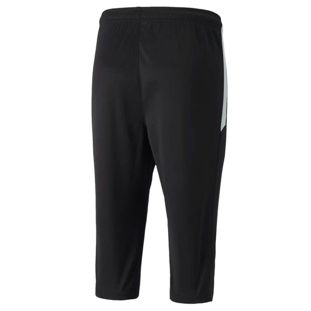 A rear view of three-quarter length black athletic training pants featuring an elastic waistband and a white panel on the right side.